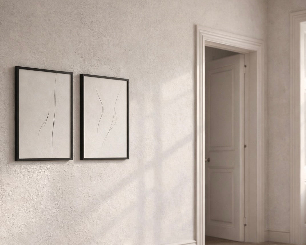 Two framed artworks on a textured wall with a door in the background