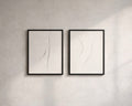 Two framed abstract artworks on a gray wall