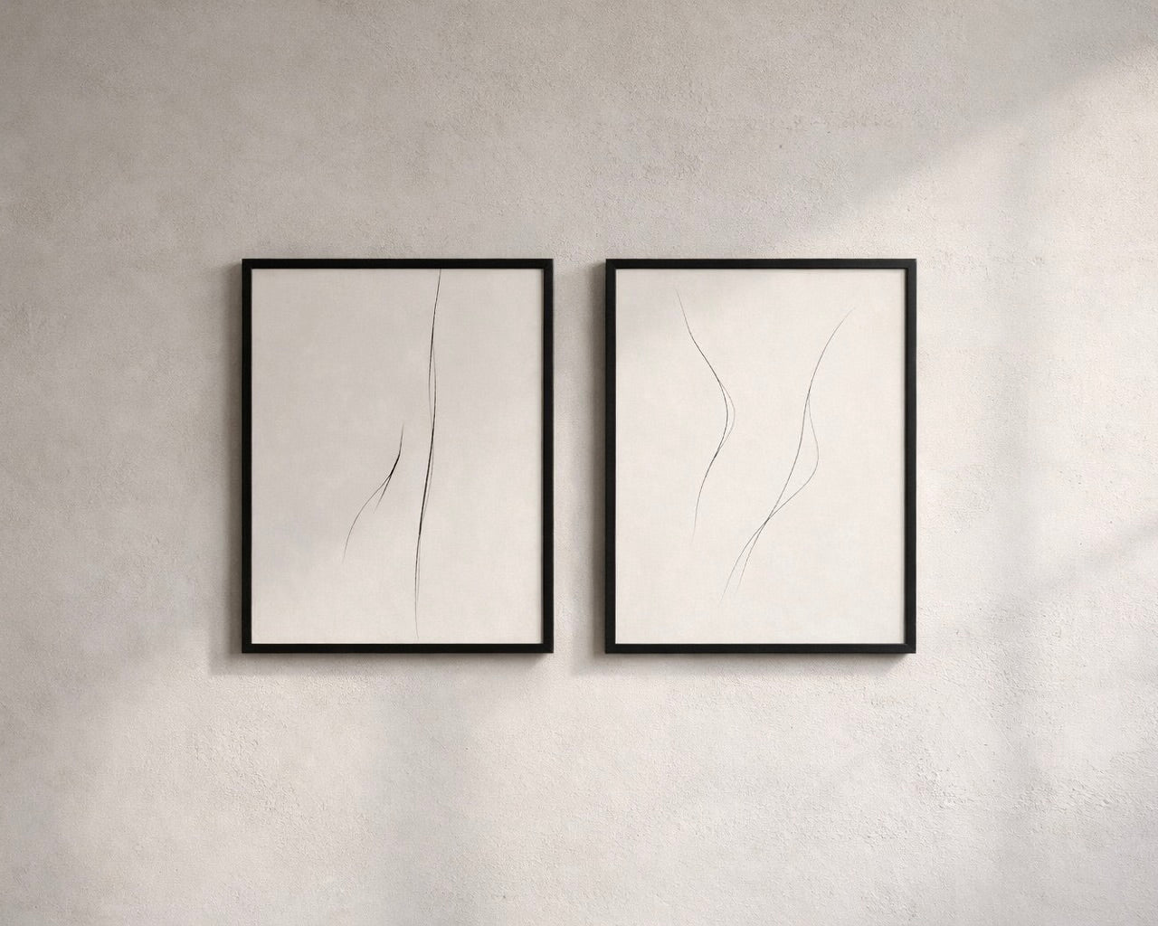 Two framed abstract artworks on a gray wall