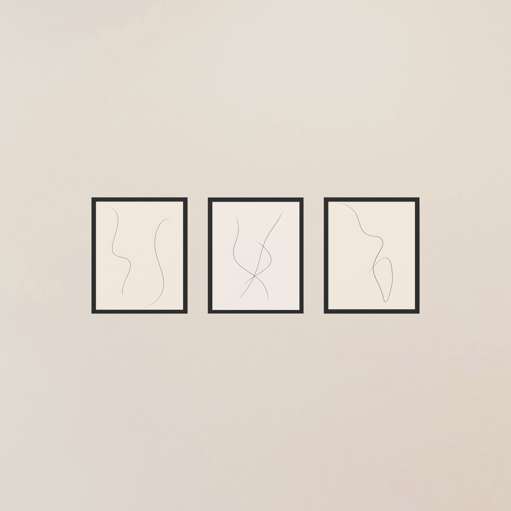 Three framed abstract line art pieces on a beige wall